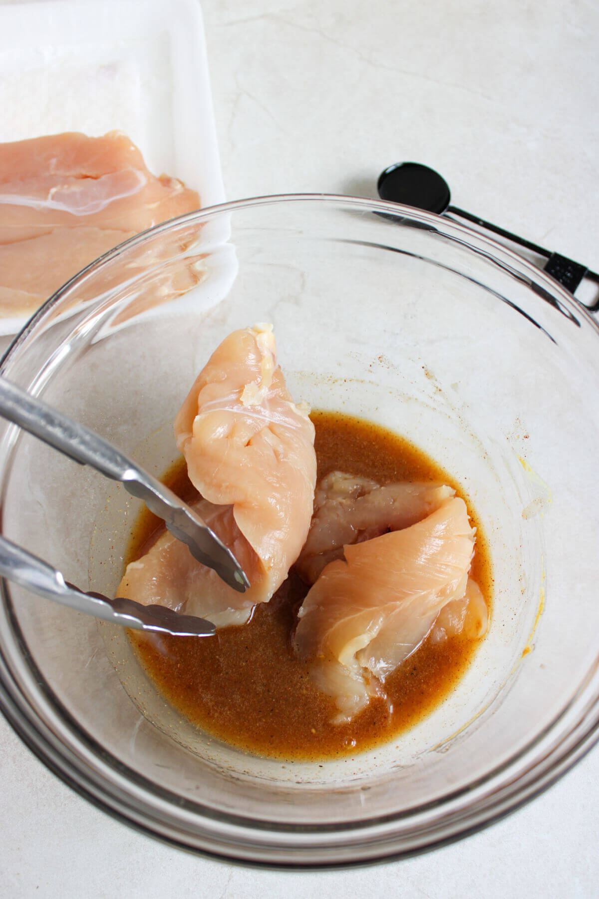 Chicken tenderloins being dipped in the honey mustard marinade.