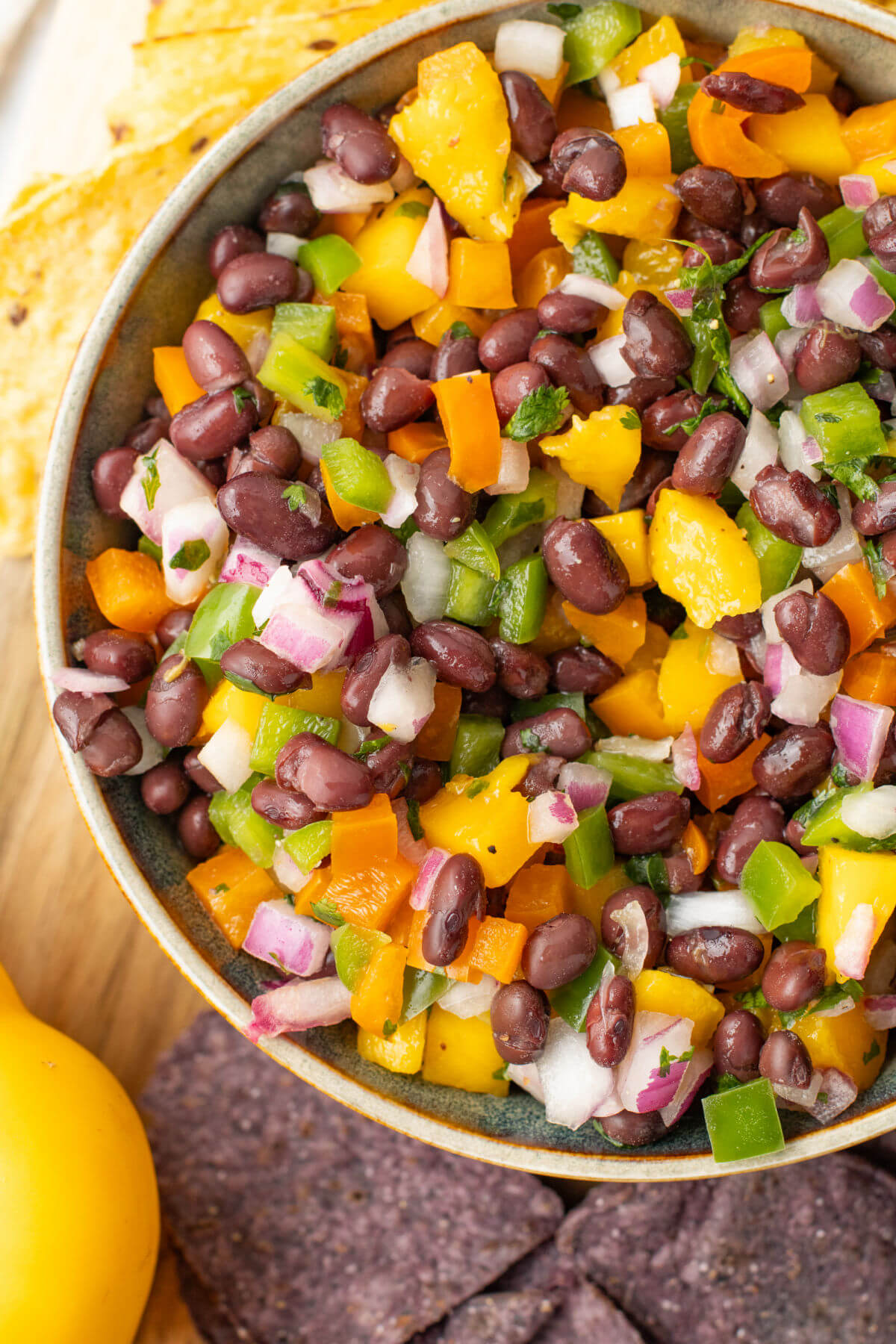 Mango black bean salsa in a bowl with tortilla chips next to it.