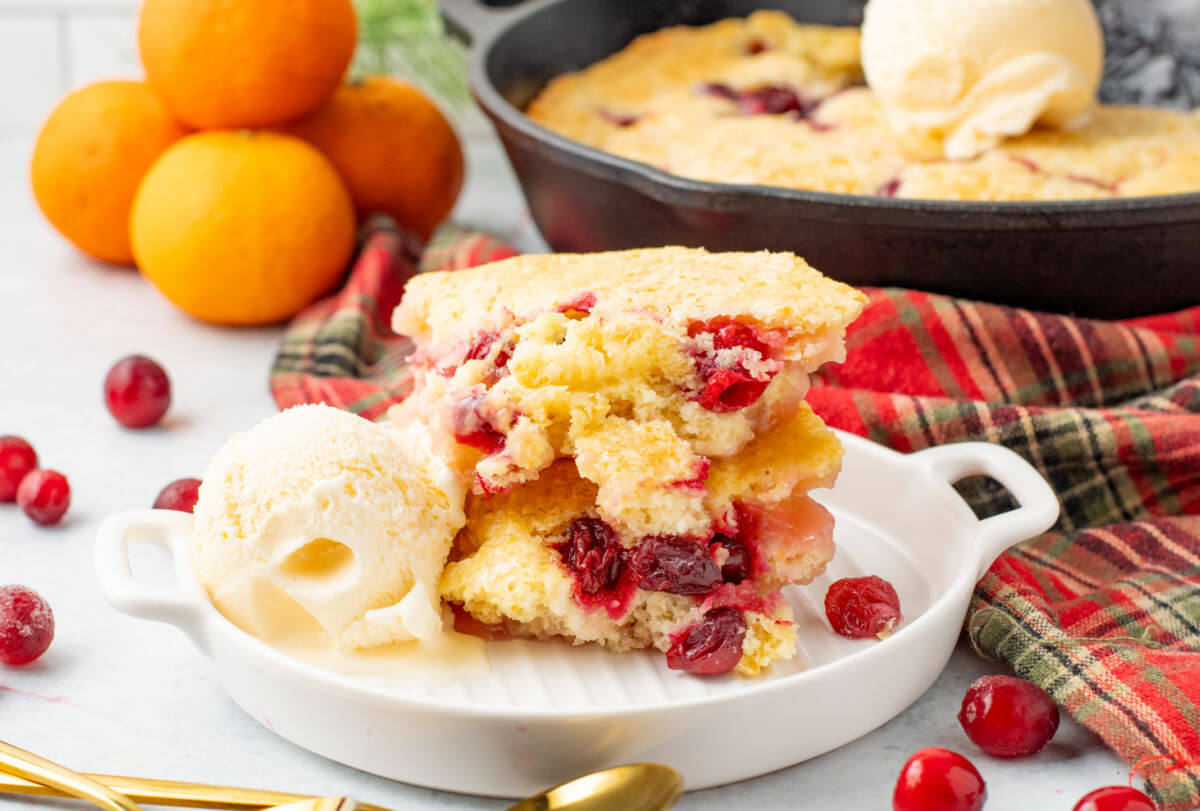 Cranberry orange cobbler on a plate with ice cream.