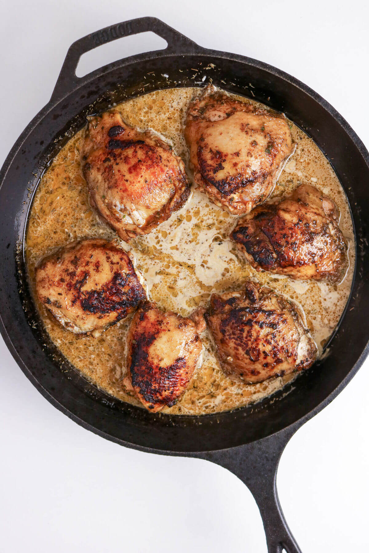 Jerk chicken and rice recipe in a cast iron skillet while cooking.