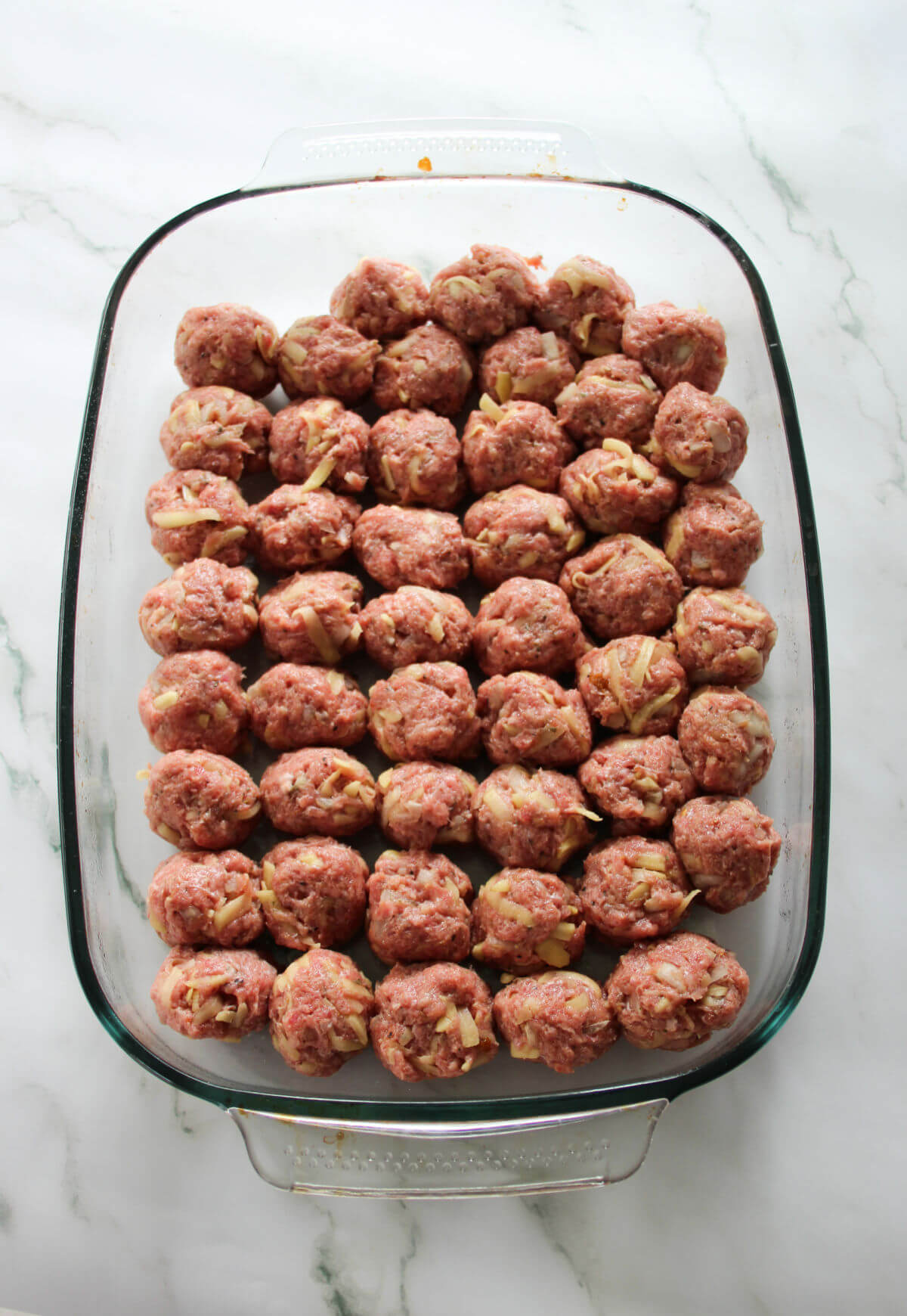 Savory meatballs in a glass baking dish.