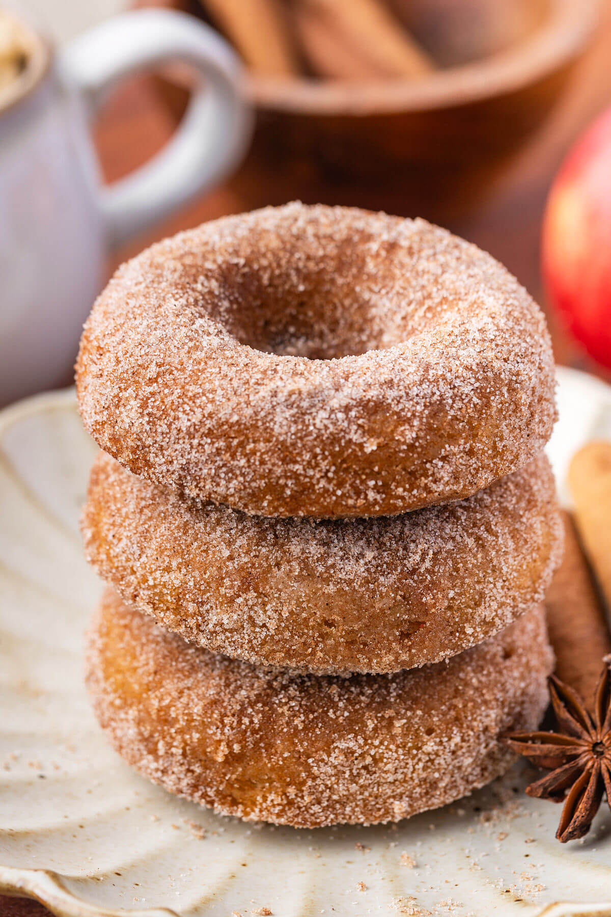 A stack of sourdough apple cider donuts on a plate.