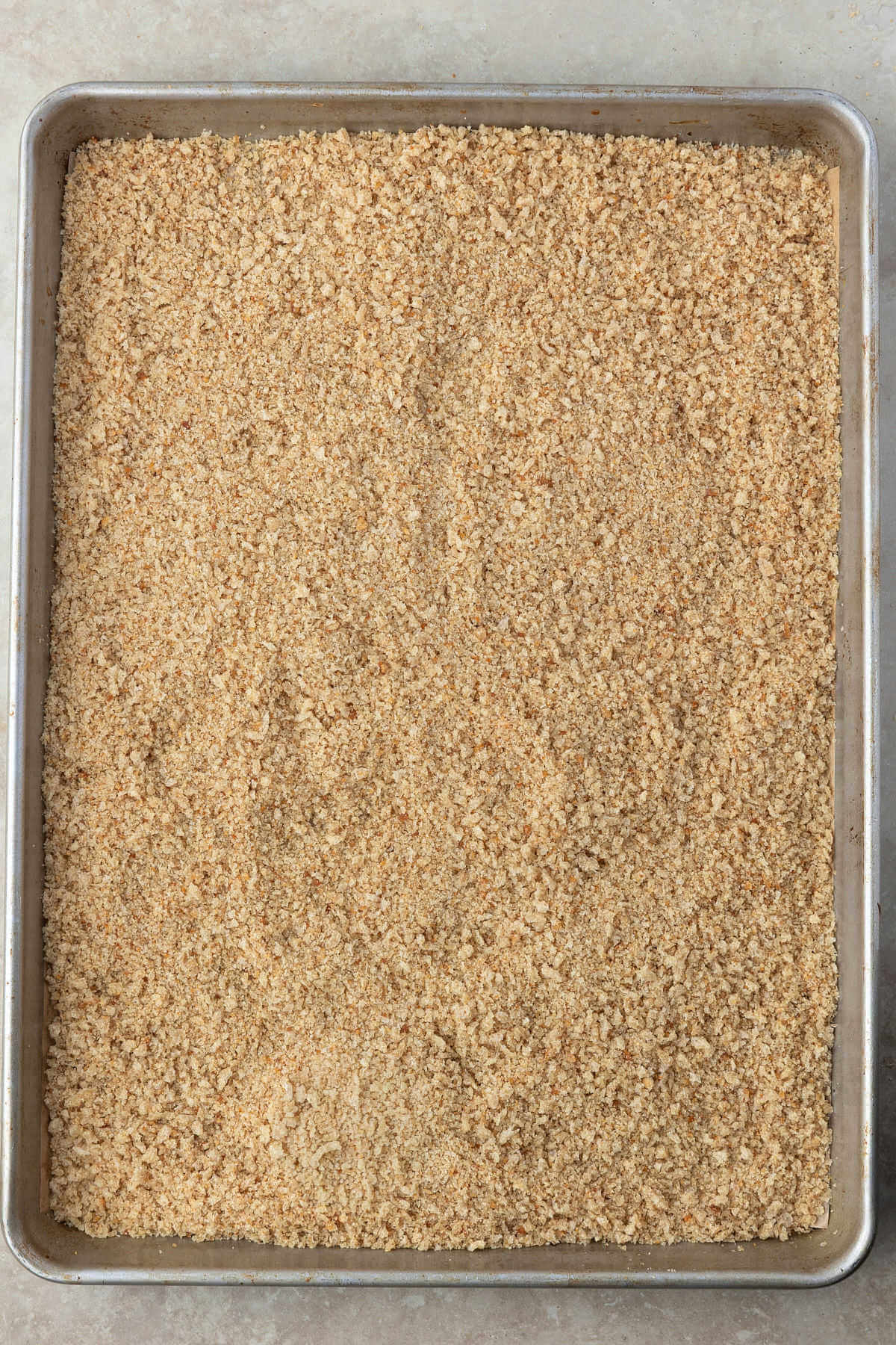 Sourdough breadcrumbs on a sheet pan to cool after pulsing in food processor.