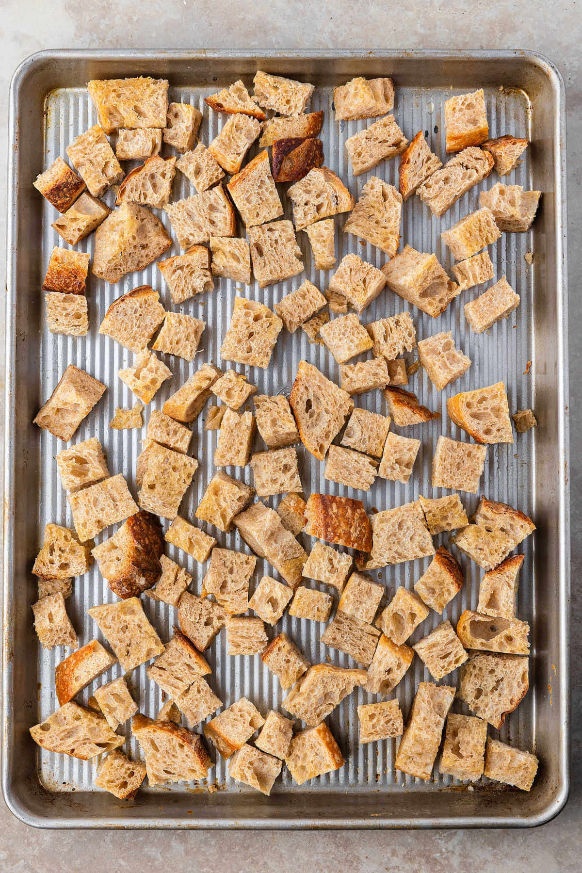 Sourdough bread cubes on a sheet pan for sourdough breadcrumbs.