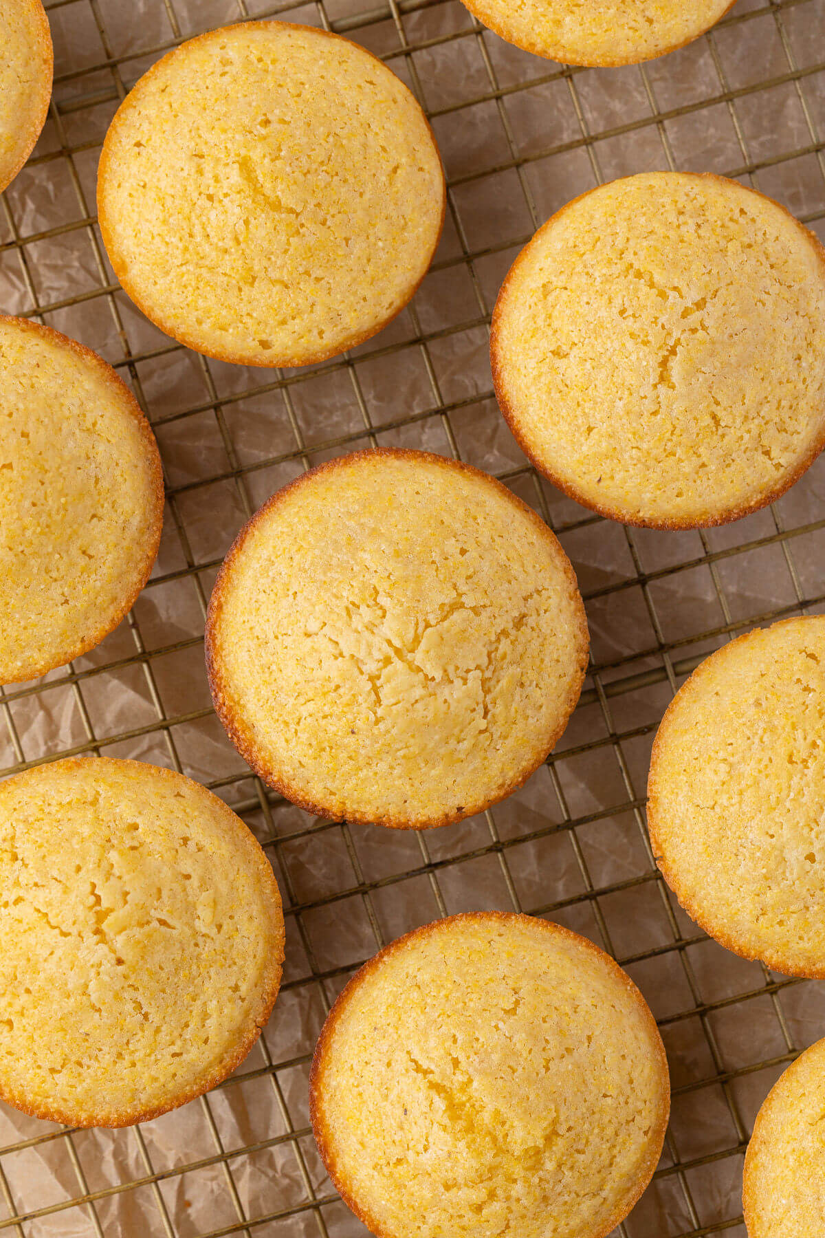 Sourdough cornbread muffins on a cooling rack.