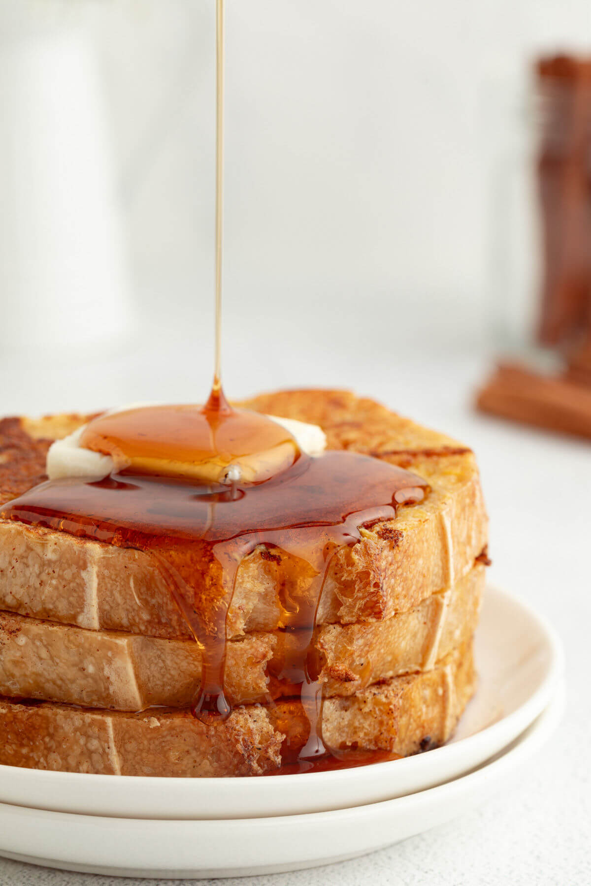 Sourdough French toast in a stack with butter and maple syrup.