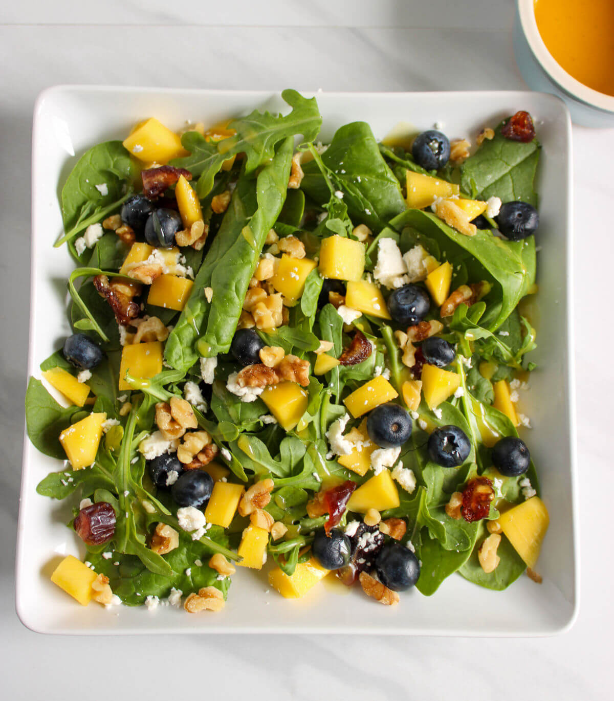 A blueberry mango fresh green salad.