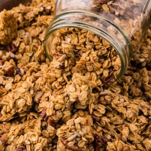 Maple pecan granola in a jar on a cookie sheet.