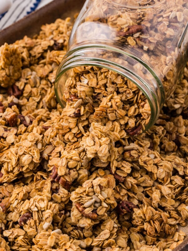Maple pecan granola in a jar on a cookie sheet.
