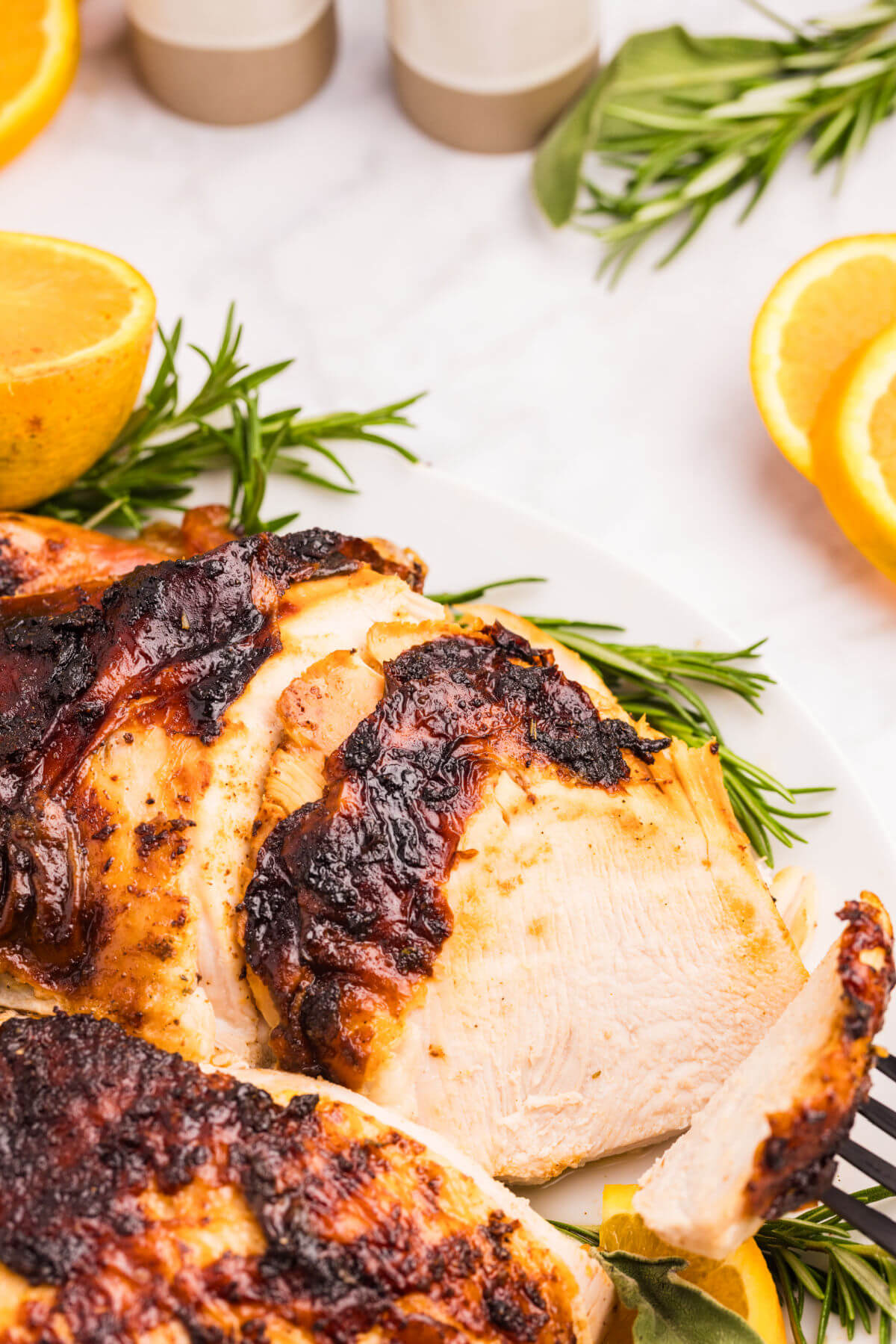 Orange glazed turkey on a plate after slicing.