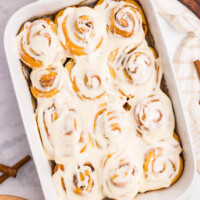 Overnight cinnamon rolls with frosting in a baking dish.