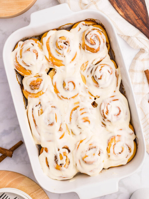 Overnight cinnamon rolls with frosting in a baking dish.
