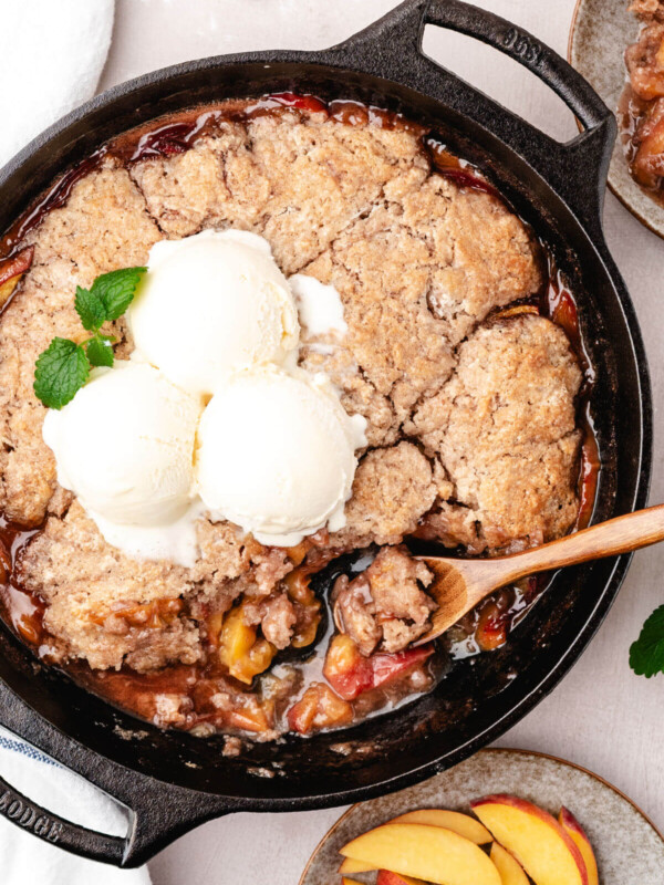 Skillet peach cobbler with vanilla ice cream on top.
