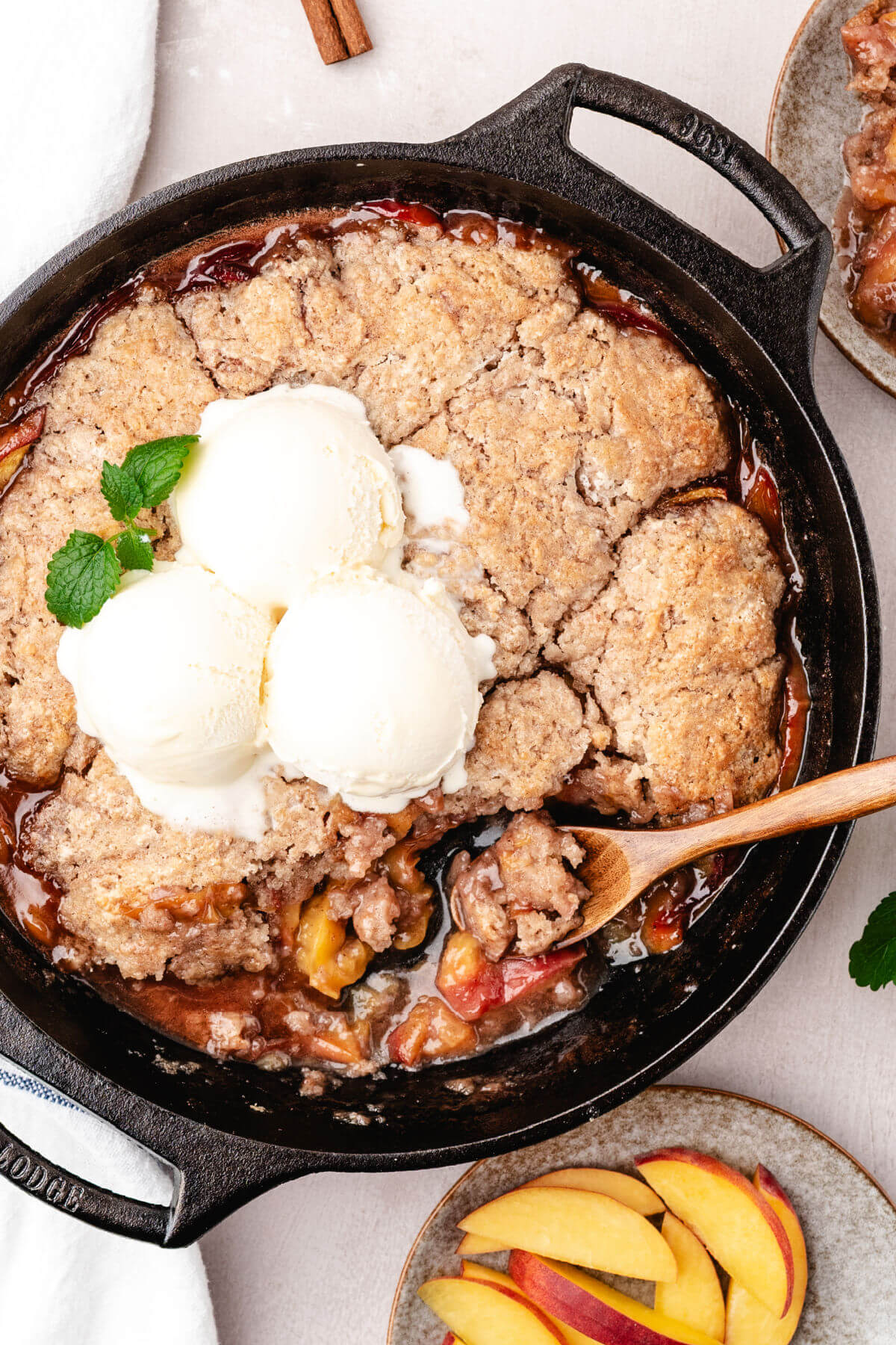 Skillet peach cobbler with vanilla ice cream on top.