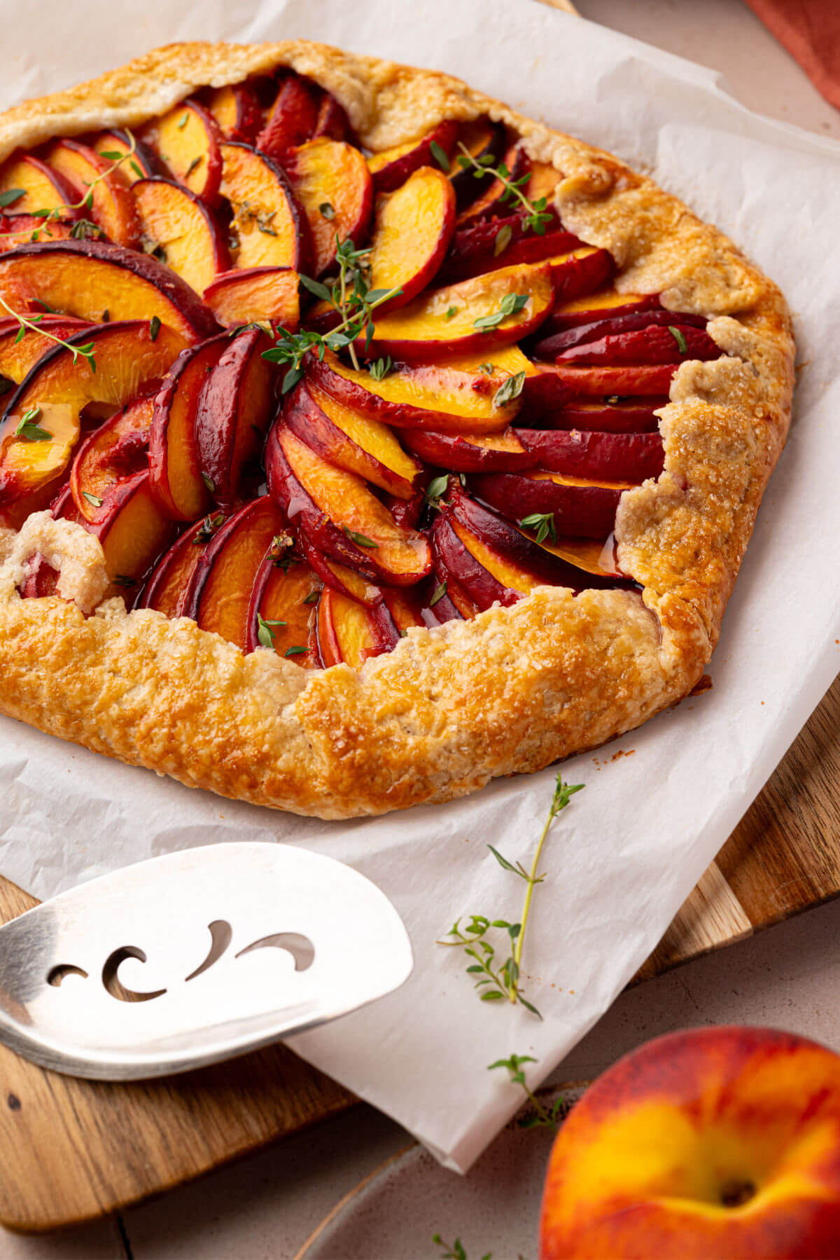 Sourdough peach galette on a piece of parchment paper.