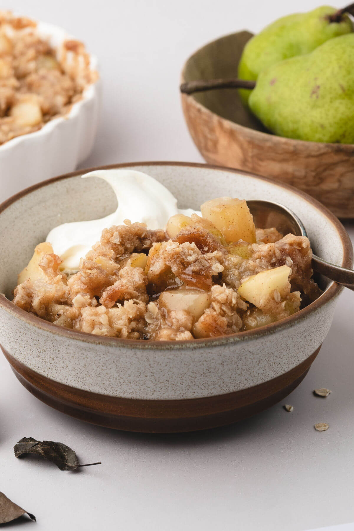 Easy pear crisp in a bowl with whipped cream for serving.