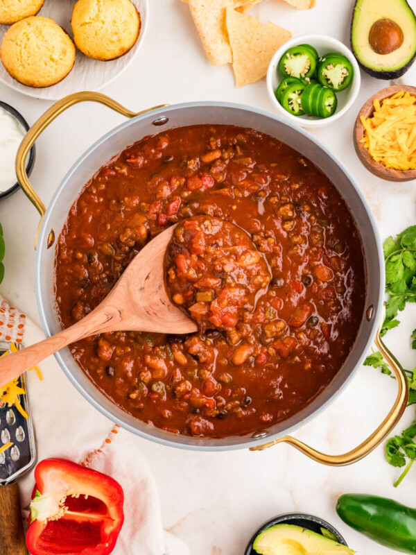 Pumpkin chili in a Dutch oven with a wooden spoon.