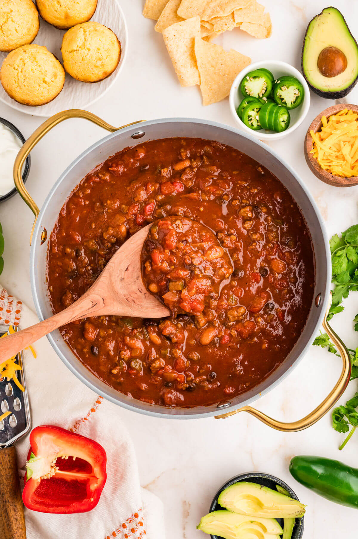Pumpkin chili in a Dutch oven with a wooden spoon.