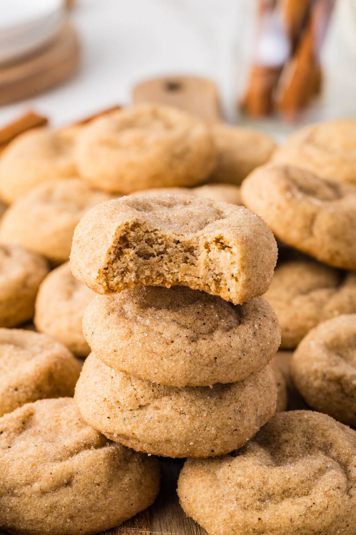 Pumpkin pie spice cookies in a pile with a bite taken out of one.