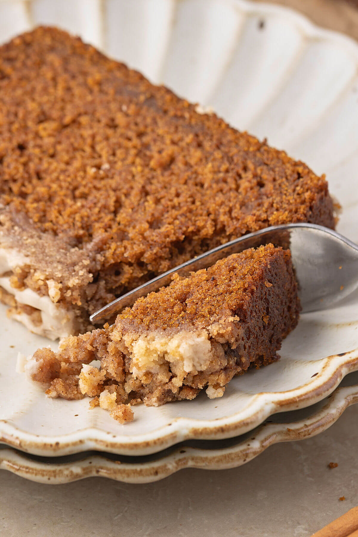 A slice of sourdough discard pumpkin bread with streusel topping and glaze on a plate.