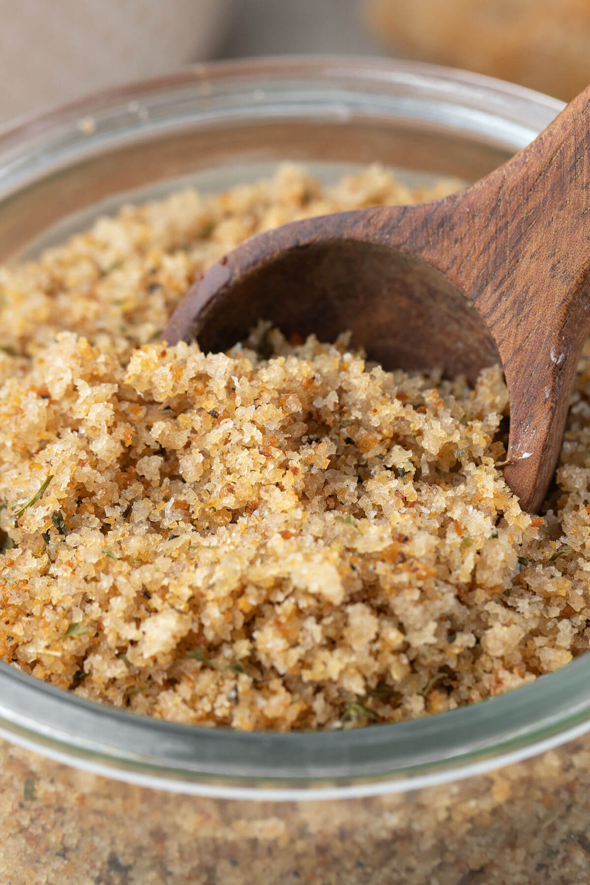 Adding seasoned breadcrumbs recipe to a glass jar.