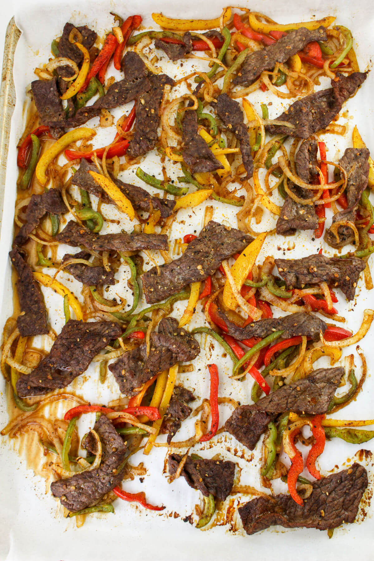 Sheet pan beef fajitas on a sheet pan.
