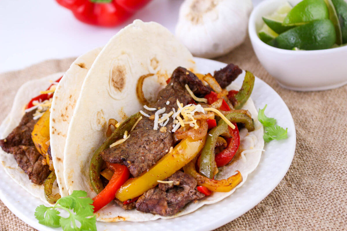 Sheet pan beef fajitas on. a plate.