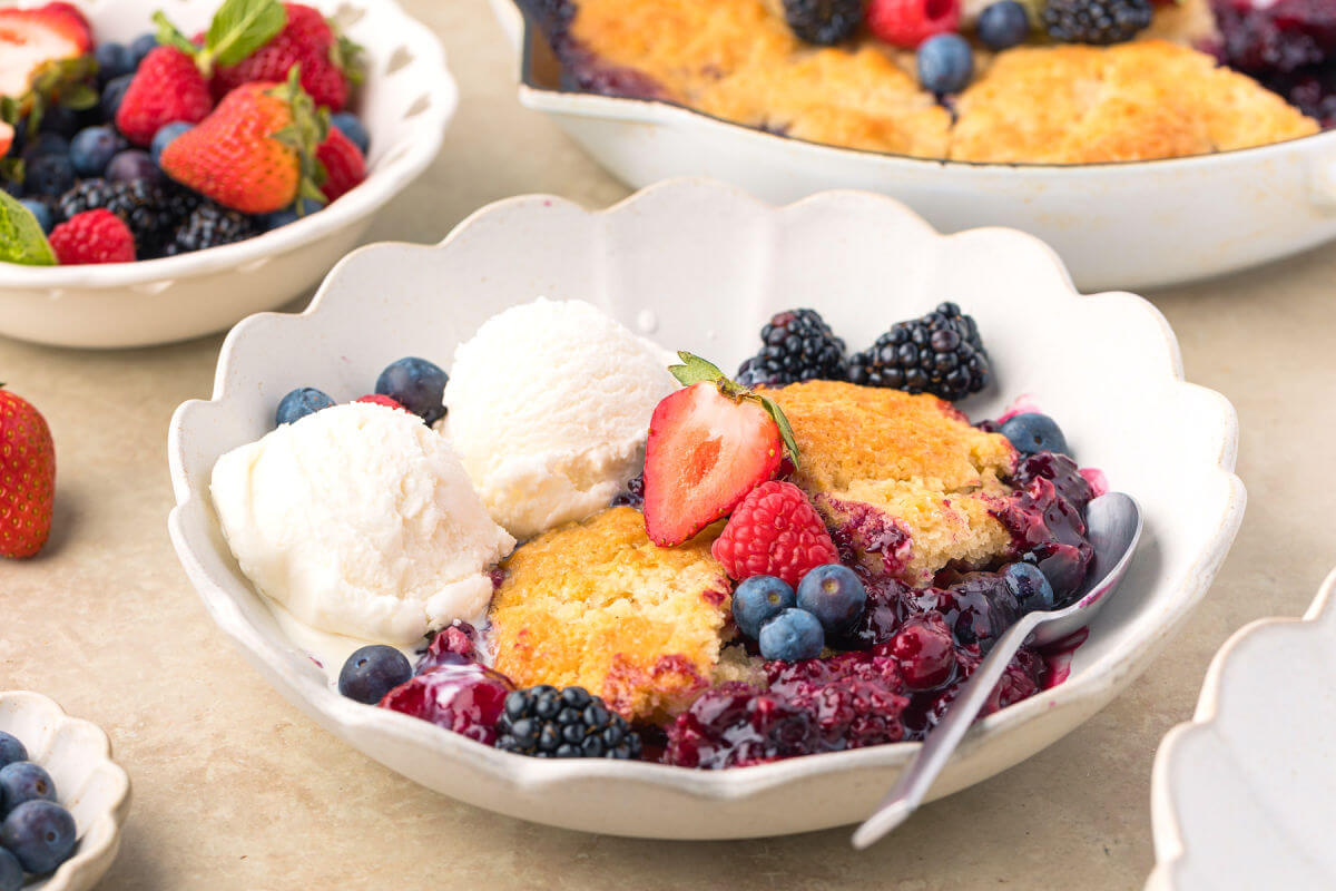 Sourdough mixed berry cobbler in a bowl with vanilla ice cream.