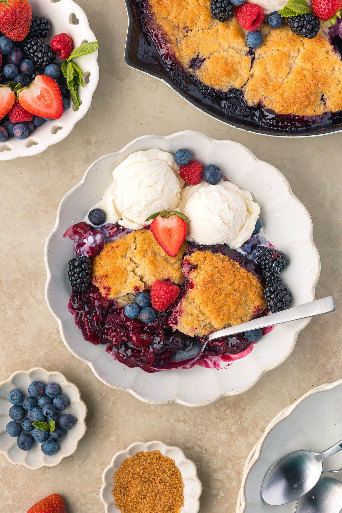 Sourdough mixed berry cobbler in a bowl with ice cream for serving.