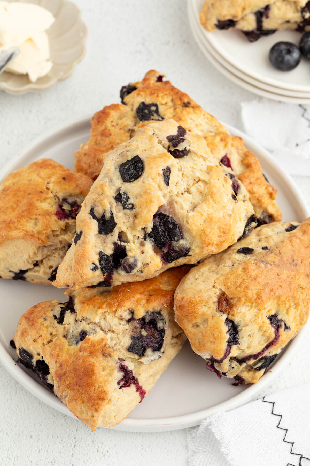 Sliced sourdough blueberry scones piled on a plate.
