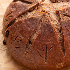 Loaf of sourdough chocolate chili bread on a piece of parchment paper.