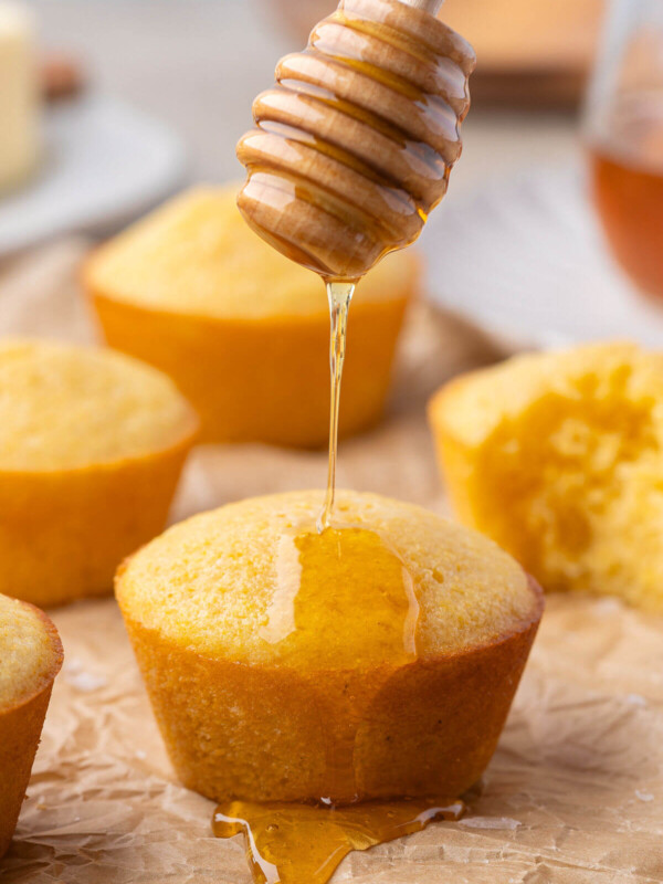 Sourdough cornbread muffins drizzled with honey.