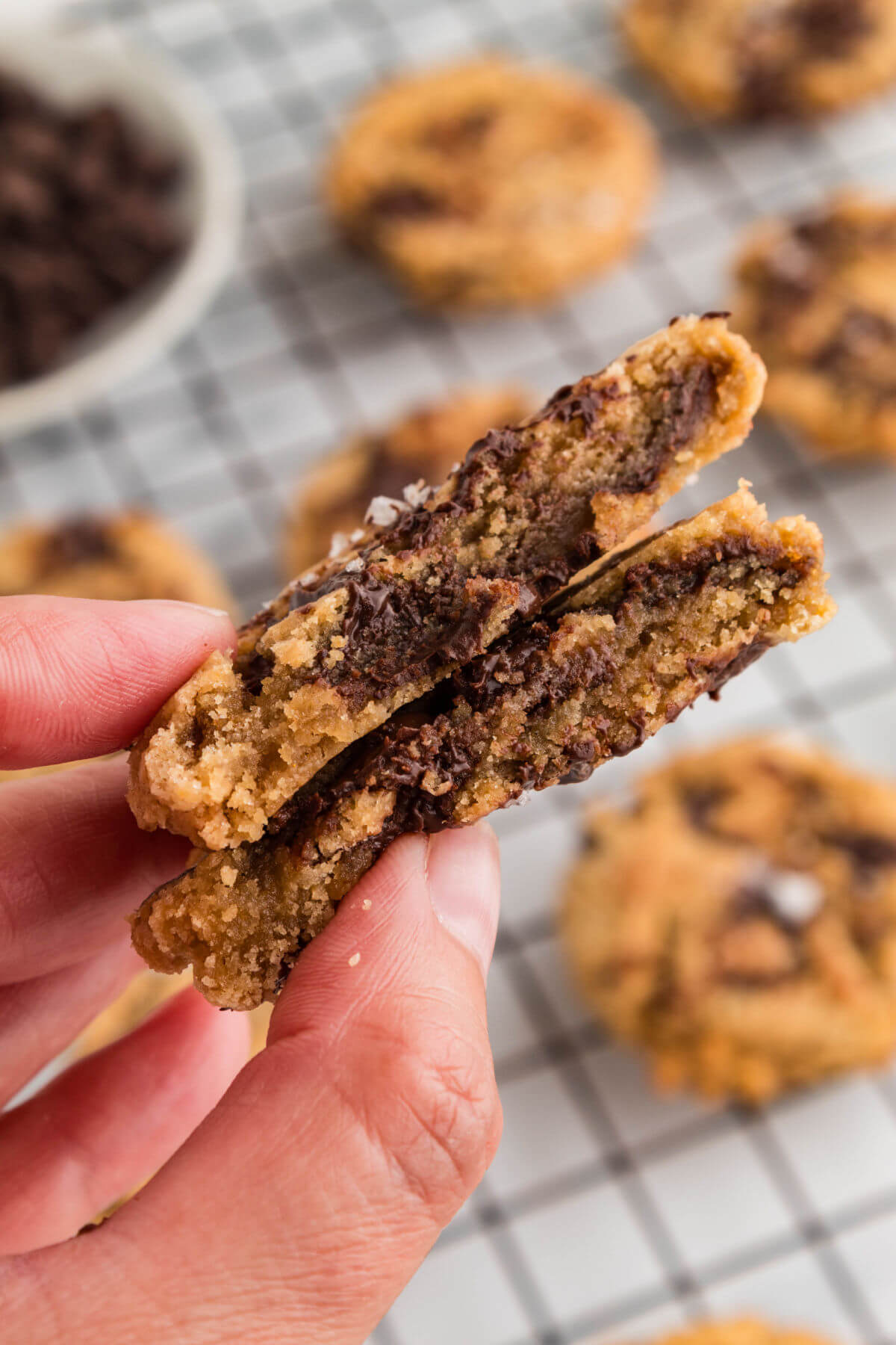 Brown butter sourdough chocolate chip cookie broken in half to show melted chocolate.