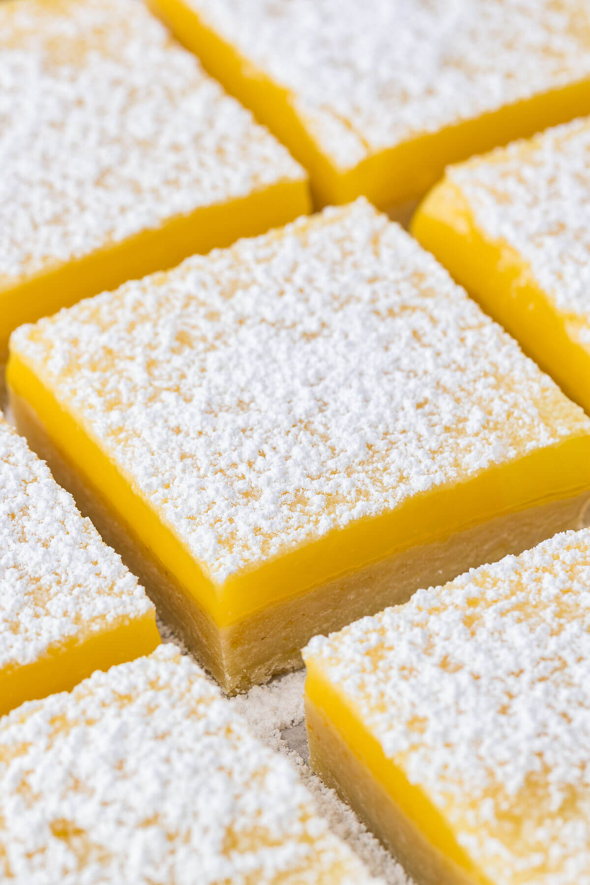 Sourdough lemon bars cut into squares and dusted with powdered sugar.