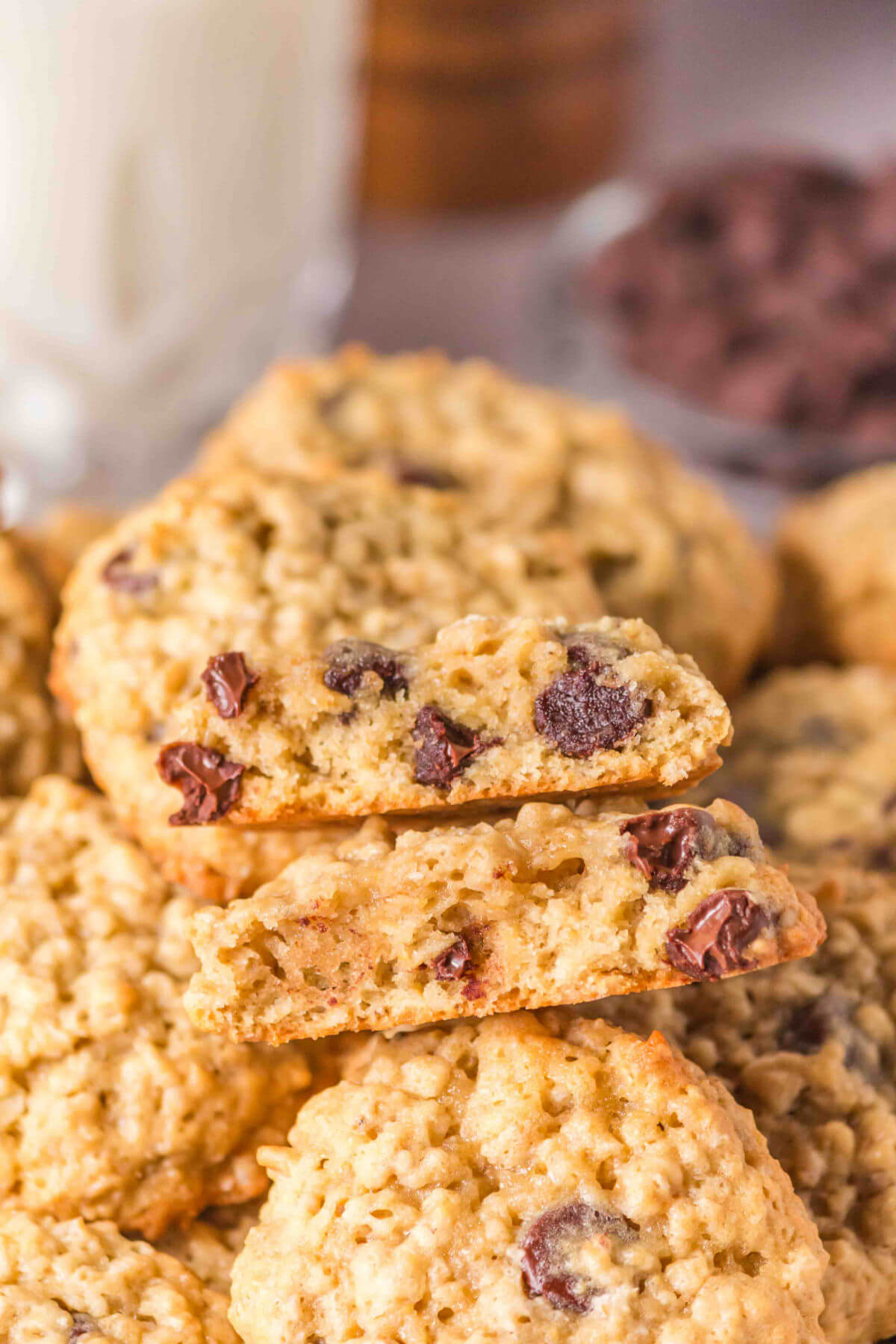 Sourdough oatmeal chocolate chip cookies in a pile with one cookie cut in half.