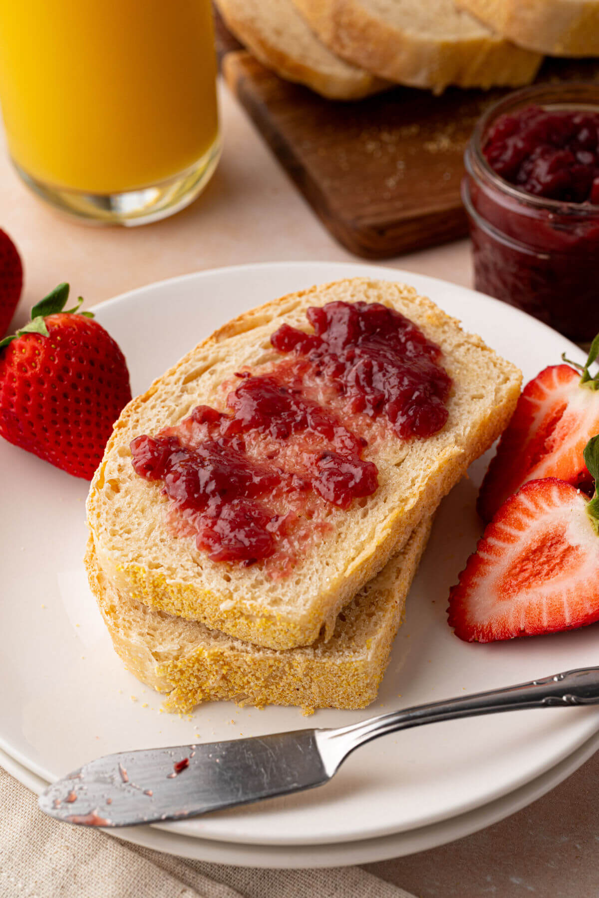A slice of sourdough English muffin bread topped with strawberry jam.