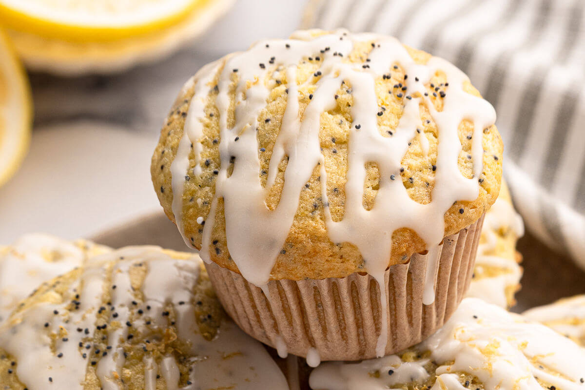 Sourdough lemon poppy seed muffin with glaze dripping down the sides.