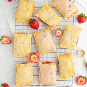 Sourdough pop tarts with strawberry frosting on a wire cooling rack.
