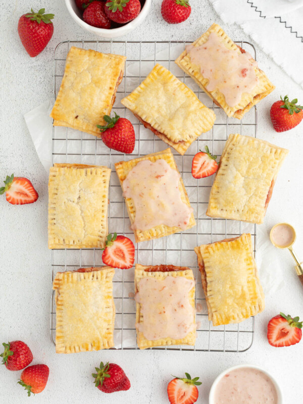 Sourdough pop tarts with strawberry frosting on a wire cooling rack.
