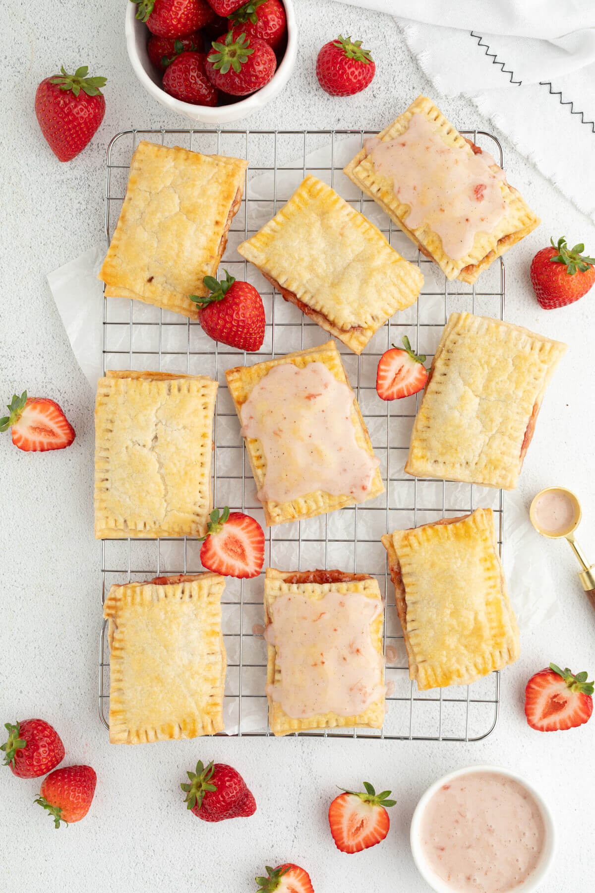 Sourdough pop tarts with strawberry frosting on a wire cooling rack.