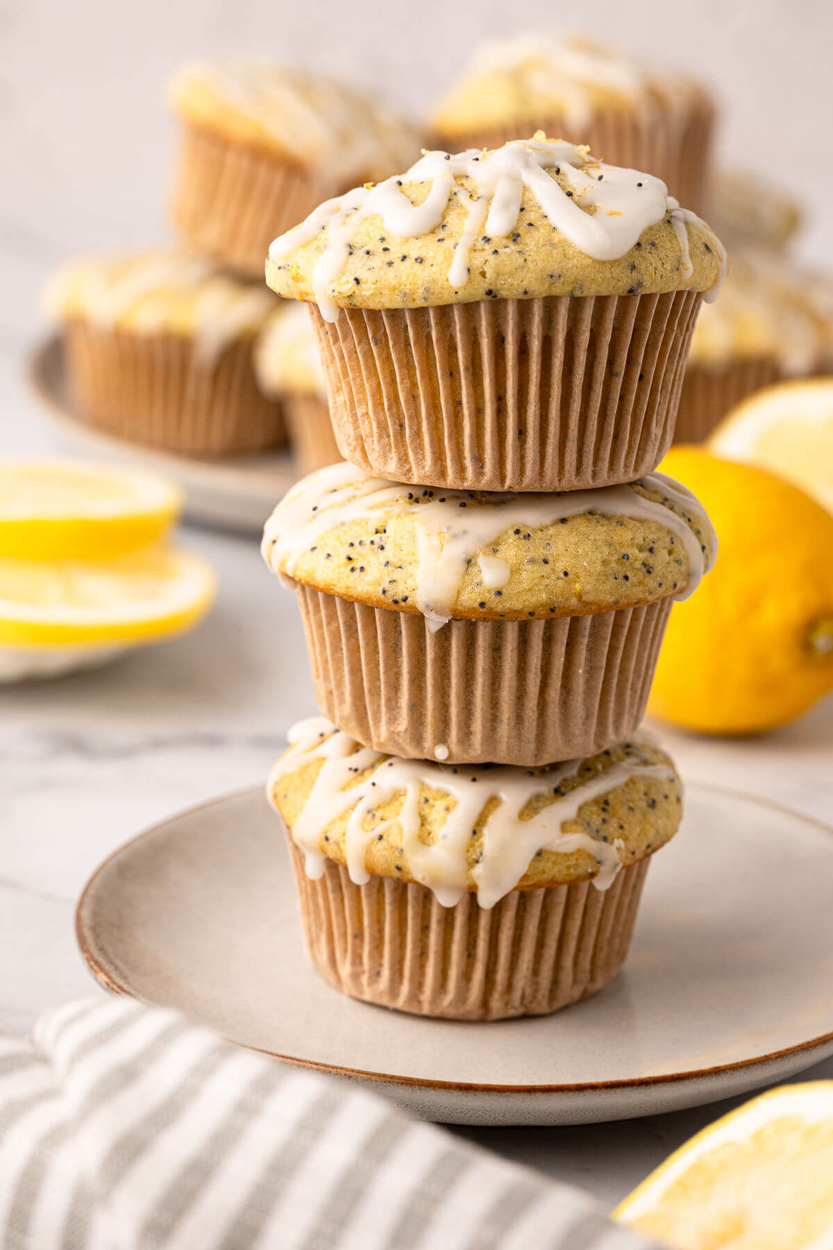 Sourdough lemon poppy seed muffins in a stack on a plate.