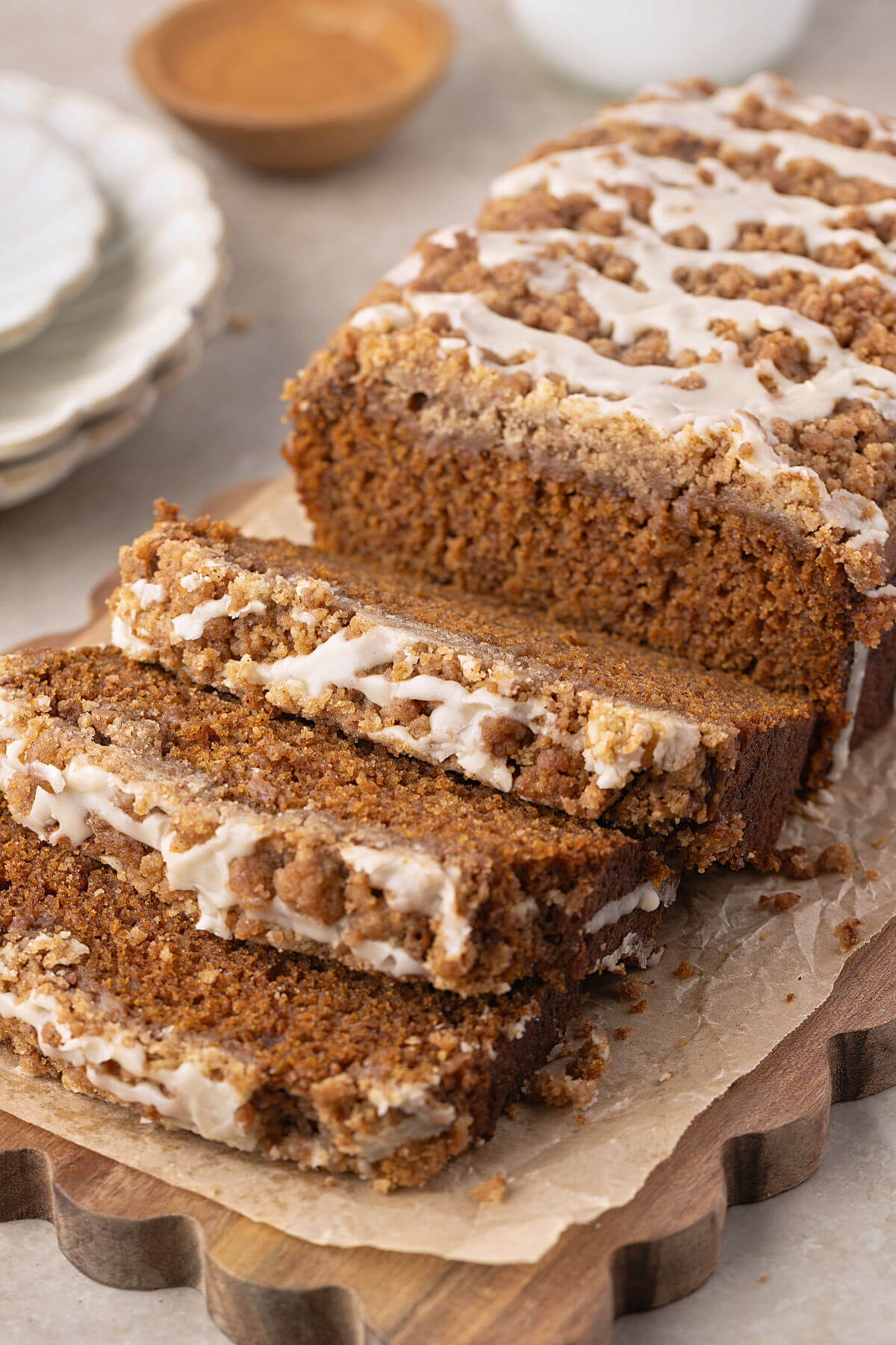 A loaf of sourdough discard pumpkin bread on a cutting board with three slices cut from the loaf.