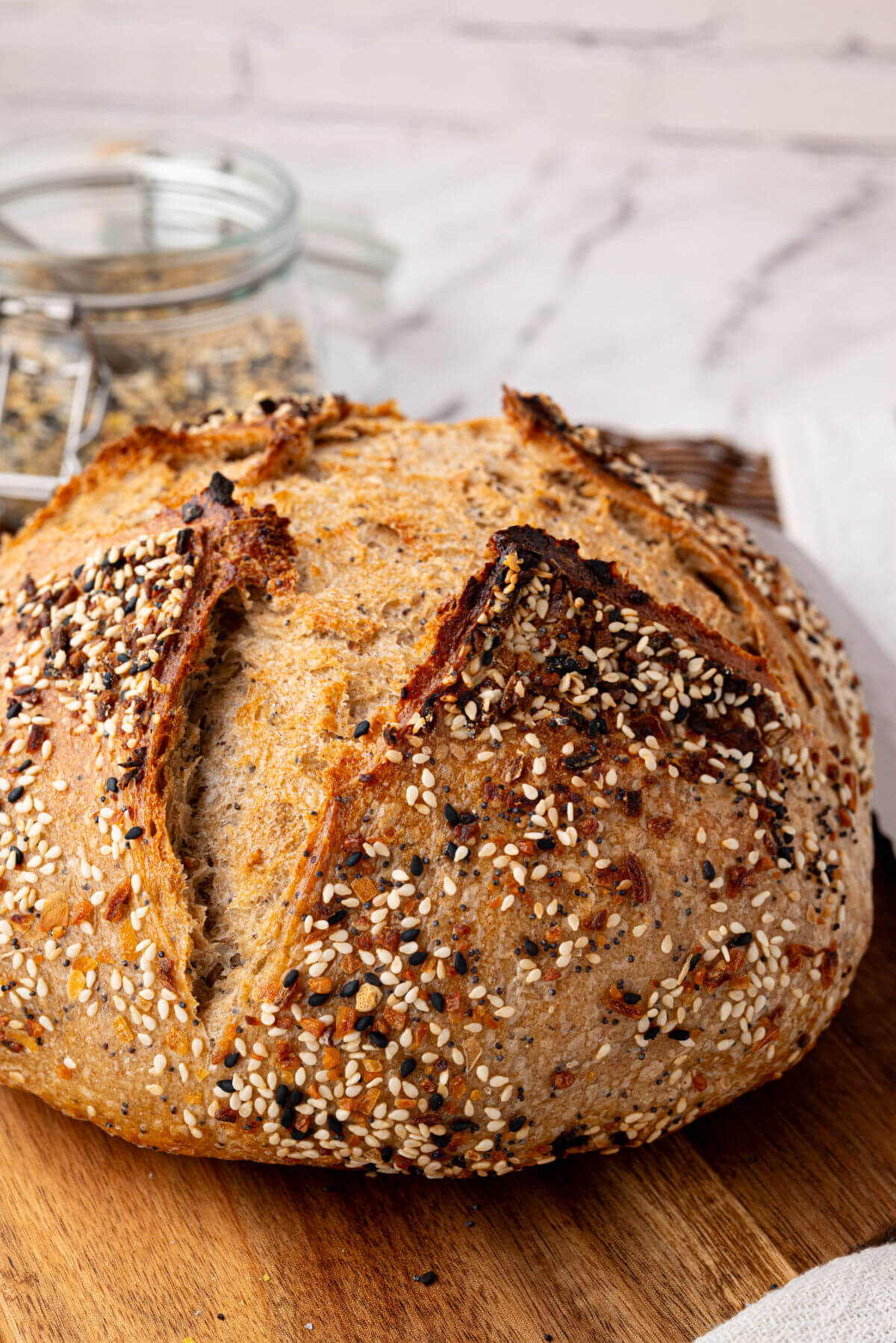 Everything Bagel sourdough bread loaf on a cutting board.