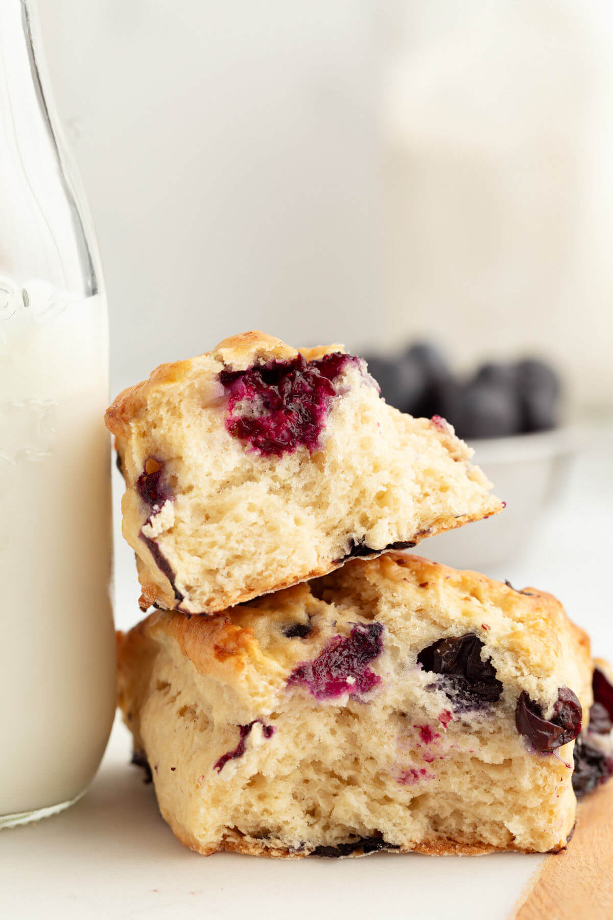 Two sourdough blueberry scone slices next to some milk.