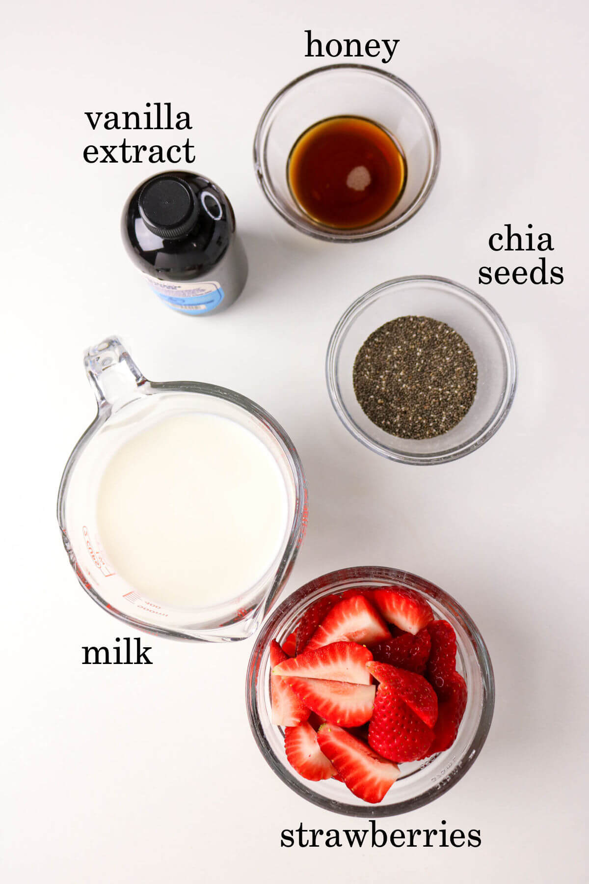 Ingredients for strawberry chia seed pudding in small bowls.