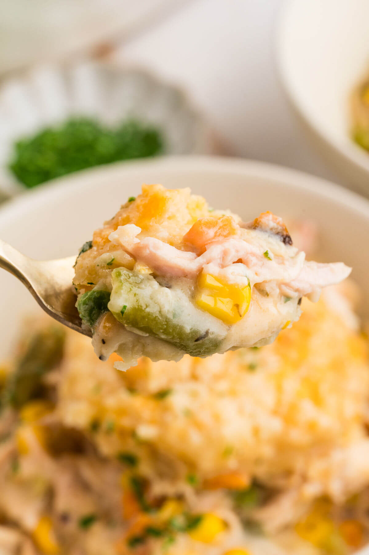 Turkey pot pie being served from a spoon.