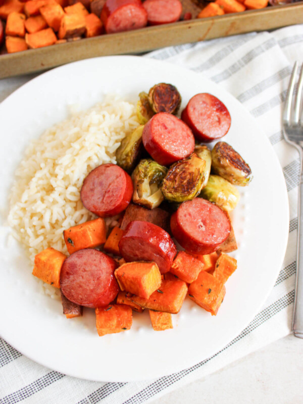 Sheet pan sausage and veggies recipe on a plate.