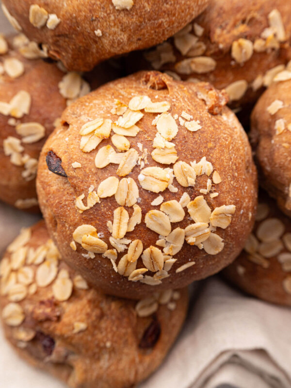 Pile of sourdough cranberry walnut rolls in a bread basket.
