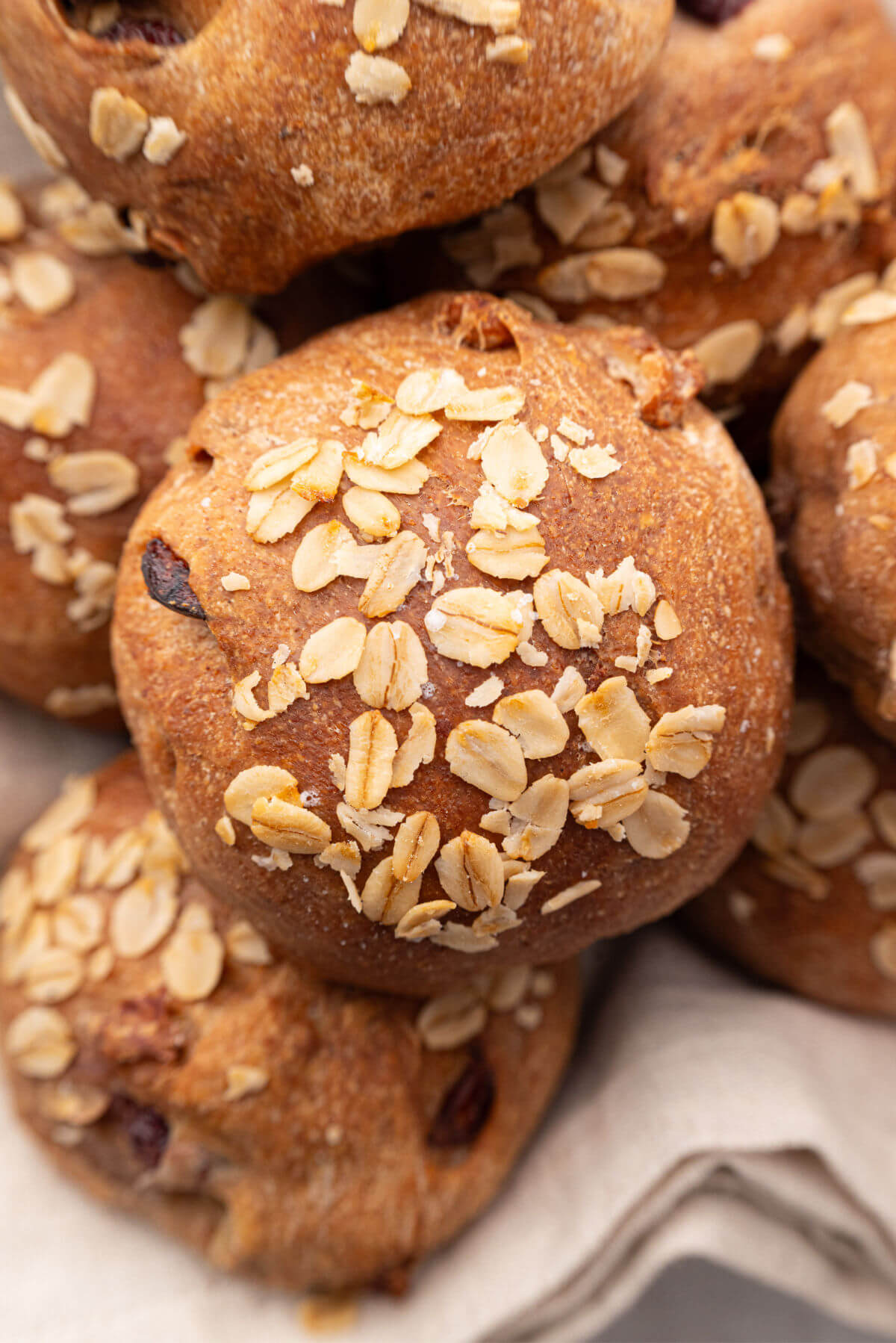 Pile of sourdough cranberry walnut rolls in a bread basket.