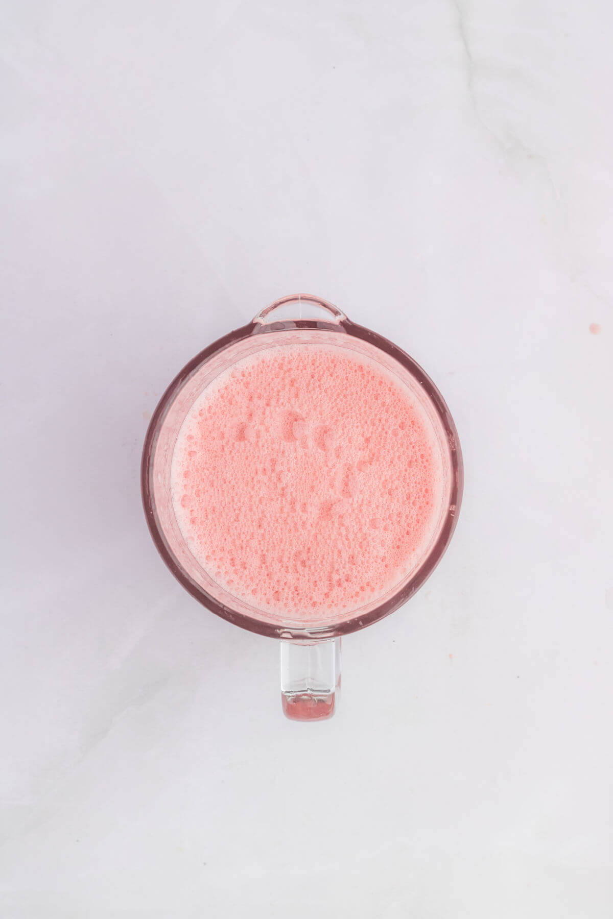 Glass blender container filled with blended watermelon lemonade.